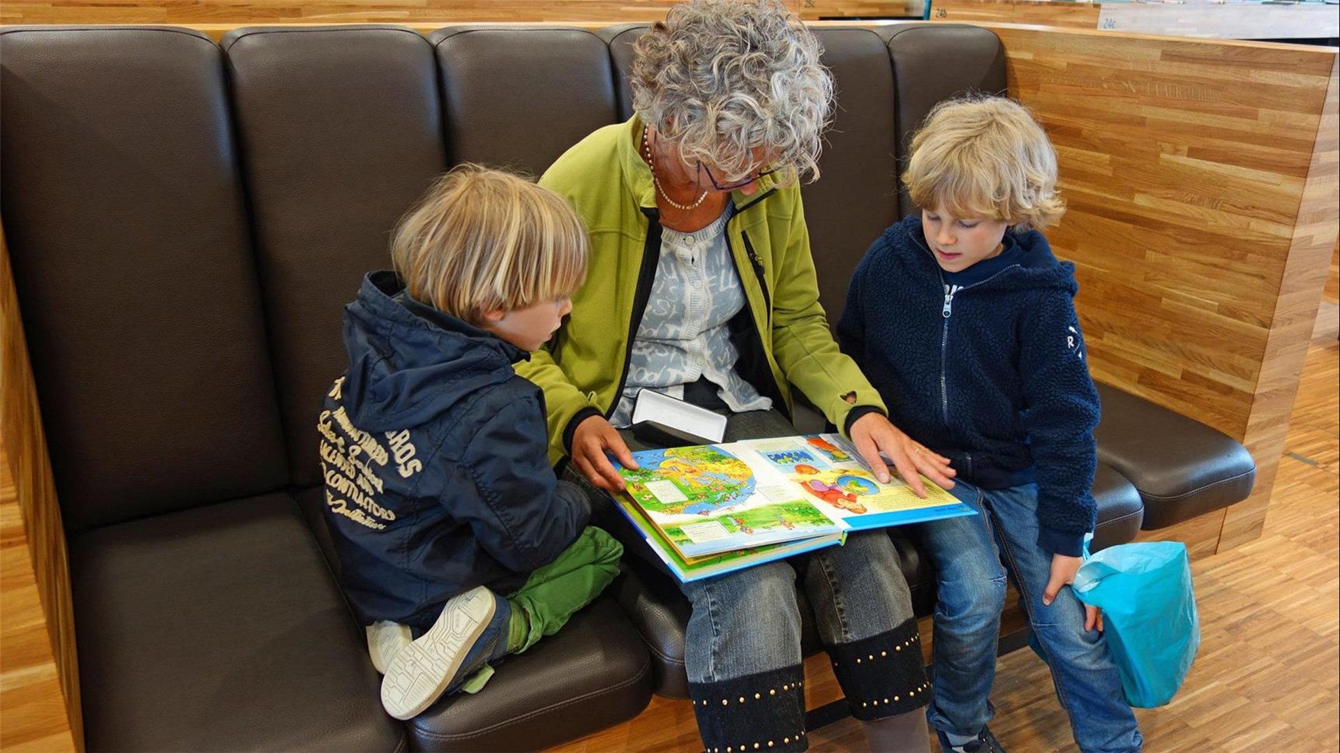 Ehrenamtliche Sprachpatin liest Kindern vor.