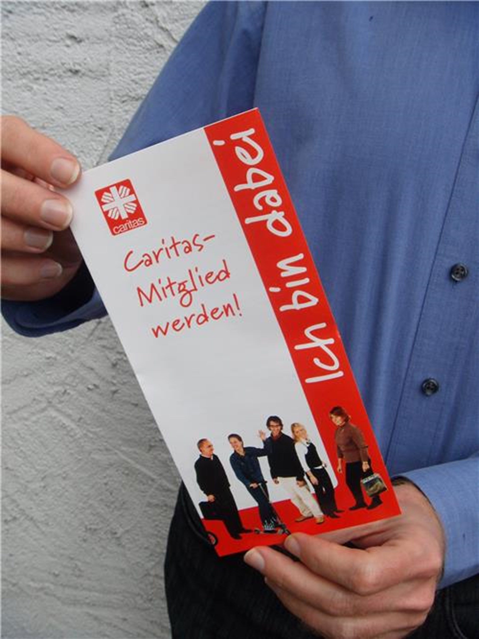 Person hält Mitgliedausweis in der Hand.