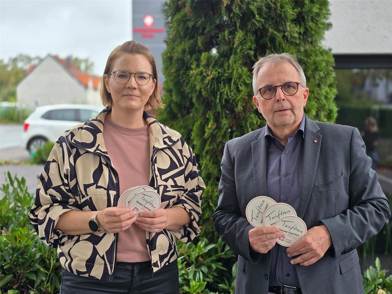 Ines Lammert und Heinz-Georg Eirund nebeneinander - in ihren Händen halten Sie Bierdeckel zur Aktion. 