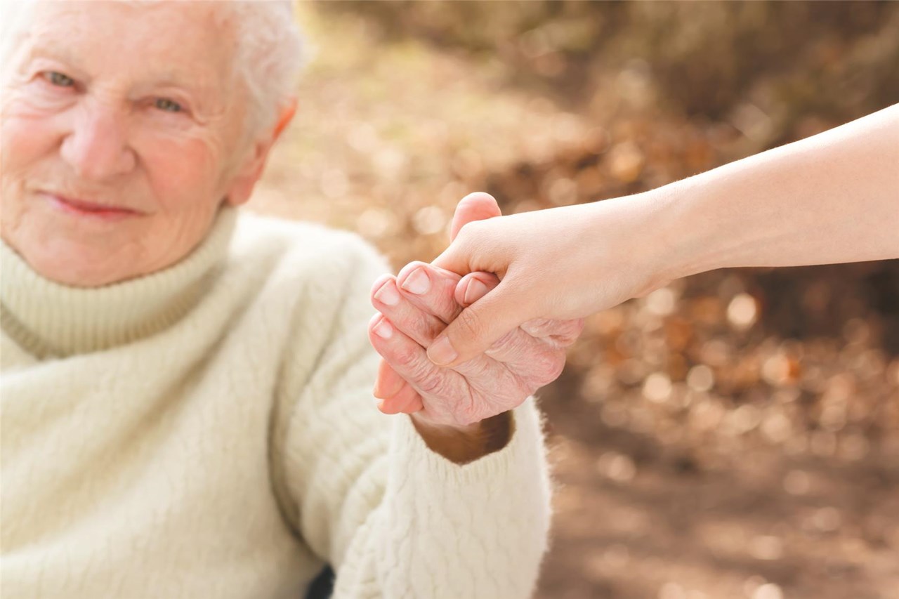 Alte Dame wird an der Hand genommen