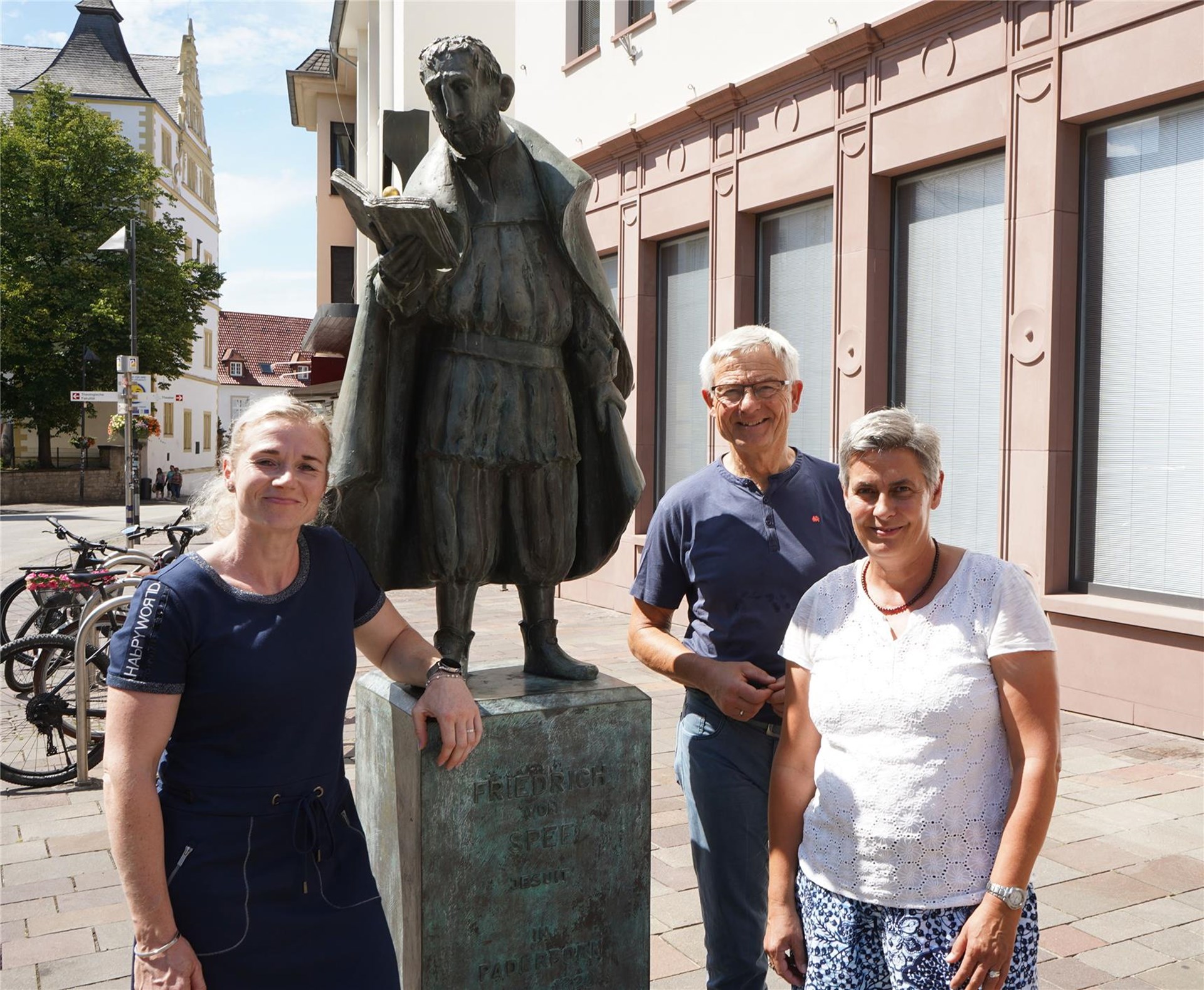 Erinnern an einer Statue des Jesuiten Friedrich Spee von Langenfeld in Paderborn an dessen bahnbrechende Schrift gegen die Hexenprozesse (v. l.): Kathrin Waldhoff, Michael Mendelin und Leonie Jedicke 
